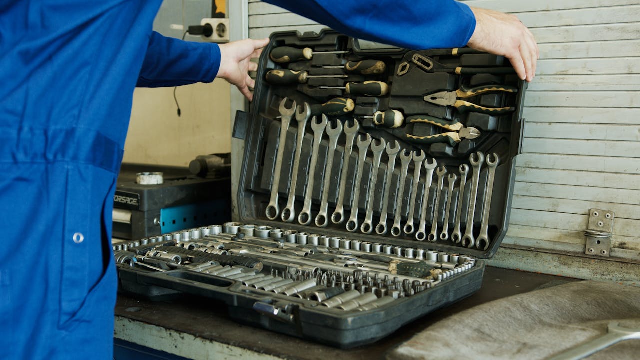 A Person Holding a Set of Tools in a Toolbox